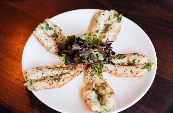 Herb-marinated shrimp plated over greens