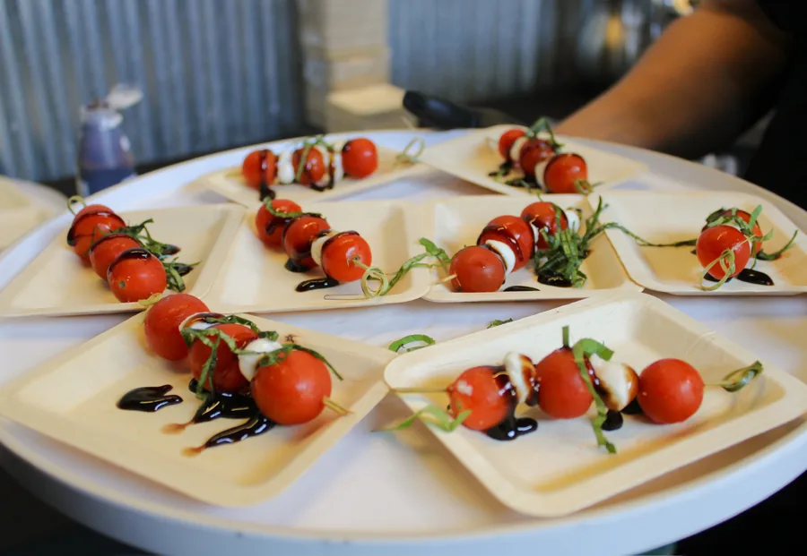 Caprese skewers with balsamic and torn basil on a passing tray