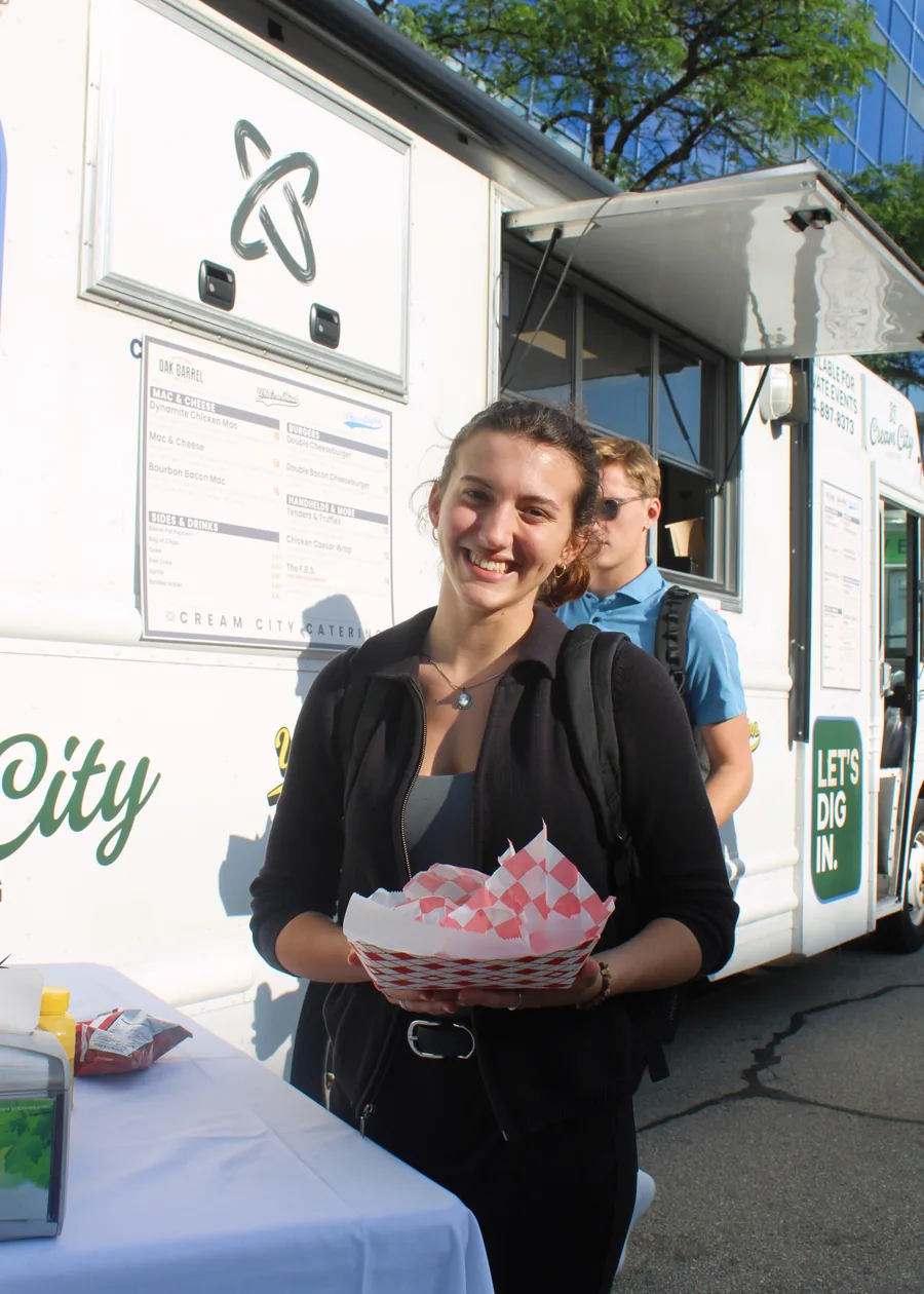 A customer holding a tray of food she has just collected from the truck window